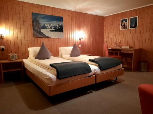 En eller flere senge i et værelse på Hotel Restaurant Waldrand , Isenfluh