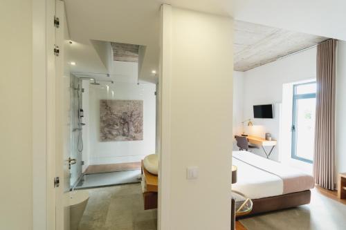 a hotel room with a white bed and white walls at Borralha Hotel, Restaurante & Spa in Vila Real