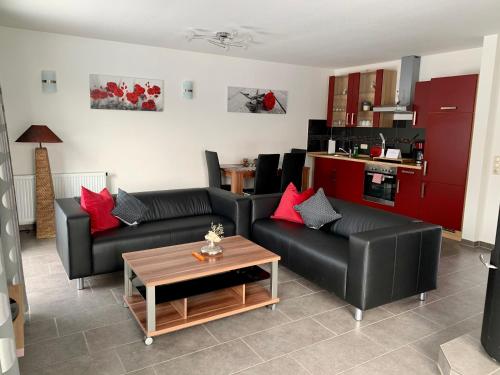 uma sala de estar com dois sofás pretos e uma mesa em Ferienhaus am Schaalsee em Zarrentin