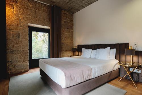 a bedroom with a large bed and a window at Borralha Hotel, Restaurante & Spa in Vila Real