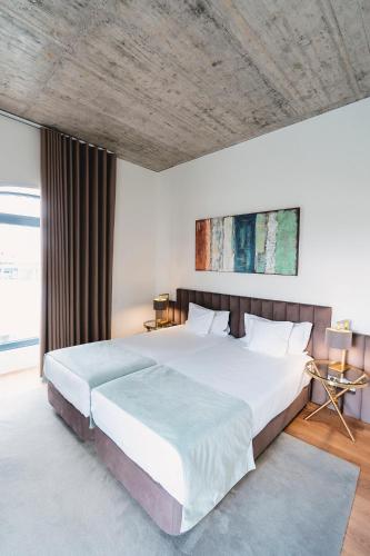 a bedroom with a large bed with a wooden ceiling at Borralha Hotel, Restaurante & Spa in Vila Real