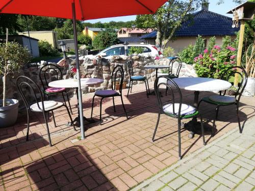 een groep tafels en stoelen onder een paraplu bij Stubnitz in Hagen