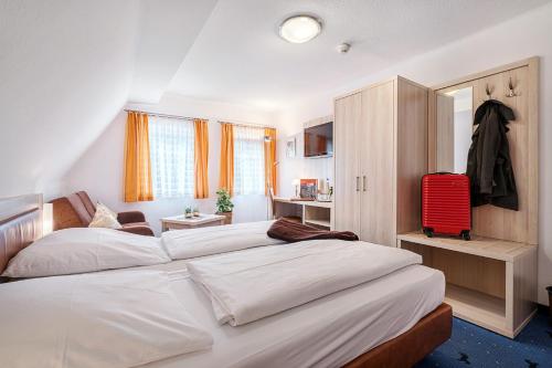 a bedroom with a bed and a dresser at Hotel Rappen Rothenburg ob der Tauber in Rothenburg ob der Tauber