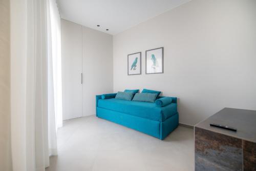a blue couch in a white room with a table at Casa Angelina in Marsala