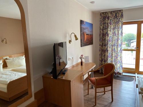 a hotel room with a desk and a bed and a mirror at Hotel Bett & Frühstück in Riedstadt