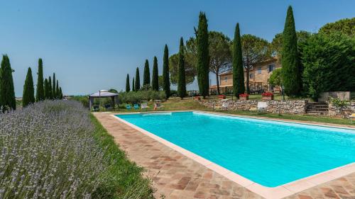 una piscina en un patio con árboles y una casa en CASALE BROLIO 12&2, Emma Villas, en Cortona