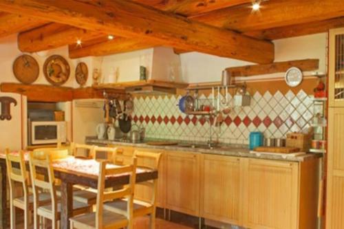 a kitchen with a table and some chairs and a table and a kitchen at La casa di Chiara in Marmora