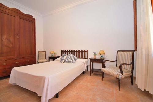 une chambre avec deux lits, une armoire et une chaise dans l'établissement 082 Casa Sa Raval ETV7915 by Mallorca Charme, à Maria de la Salut