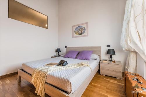a bedroom with a large bed with purple pillows at Villa Guinigi Dimora di Epoca Exclusive Residence & Pool in Lucca