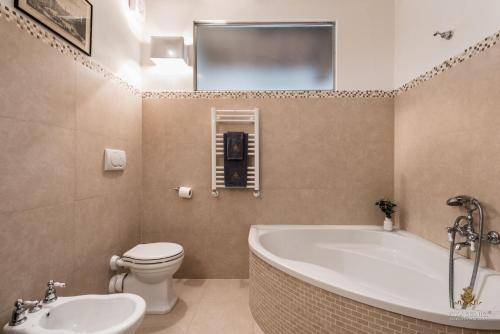a bathroom with a tub and a toilet and a sink at Villa Guinigi Dimora di Epoca Exclusive Residence & Pool in Lucca