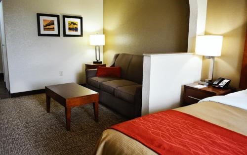 a hotel room with a couch and a bed at Comfort Inn & Suites Covington - Mandeville in Covington