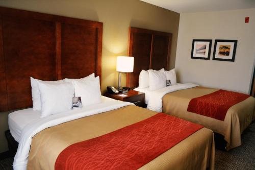 a hotel room with two beds and a telephone at Comfort Inn & Suites Covington - Mandeville in Covington