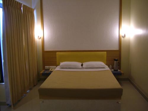 a bedroom with a large bed with two pillows at Hotel City Park, Solapur in Solapur