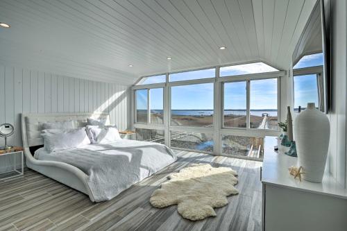 een slaapkamer met een bed en een groot raam bij Luxurious Waterfront Home with Private Pier and Views! in Georgetown