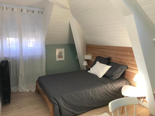 1 dormitorio con 1 cama con cabecero de madera en Maison Chiche 4 chambres indépendantes salon cuisine commune, en Bain-de-Bretagne