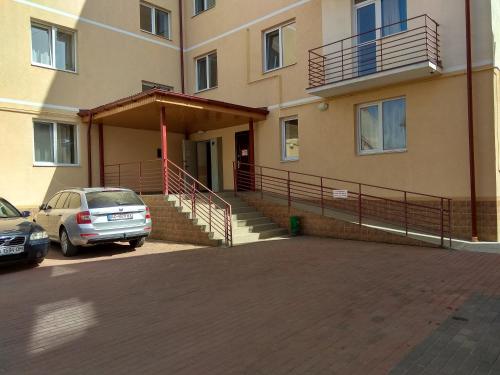 un edificio con un coche aparcado en un aparcamiento en Apartments On Beregovskaya 3 en Mukacheve