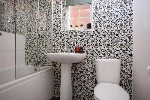 a bathroom with a toilet and a sink at Wilton Lodge By Horizon Stays in Redcar