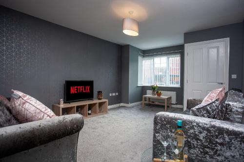 a living room with two couches and a television at Wilton Lodge in Redcar