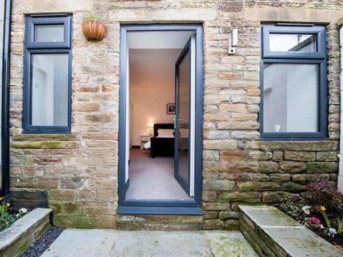 a door to a brick building with a hallway at Heaps House in Denby Dale