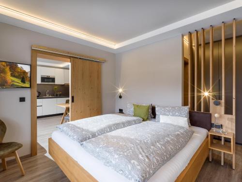 a bedroom with a large bed and a kitchen at Tirol Appartements Schwaiger in Niederndorf