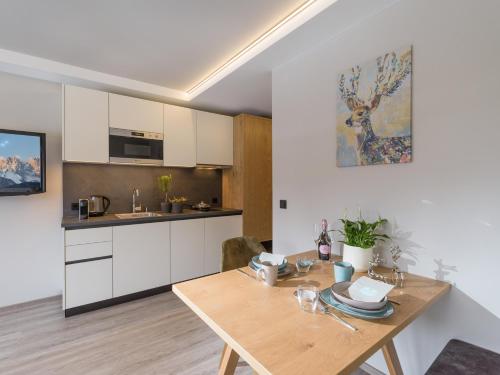 a kitchen with a wooden table in a room at Tirol Appartements Schwaiger in Niederndorf