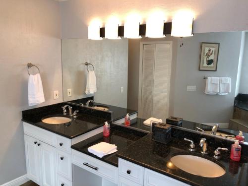 a bathroom with two sinks and a large mirror at Tiki Paradise House & pool - 10 min to Beach! in Bonita Springs