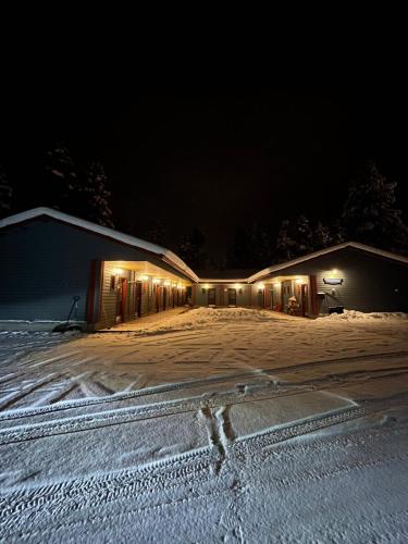 a building with lights in the snow at night at Luppoloma in Saariselka