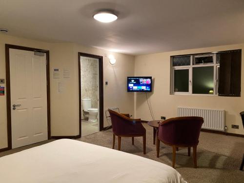 a bedroom with a bed and a table and a tv at Clifton House Brighton in Portslade