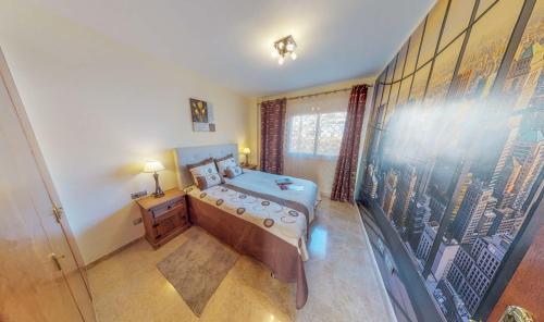 a bedroom with a bed and a painting on the wall at Casa Tres Vistas Luxury apartment with stunning views to the ocean in Puerto de Santiago