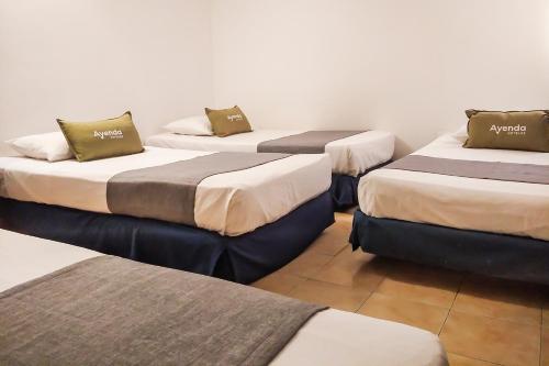 un gruppo di 4 posti letto in una camera di Ayenda 1622 Charmin a Santa Marta