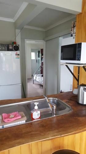 a kitchen with a microwave and a sink at Jacks place in Moeraki
