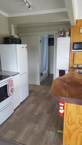 a kitchen with a stove a refrigerator and a sink at Jacks place in Moeraki