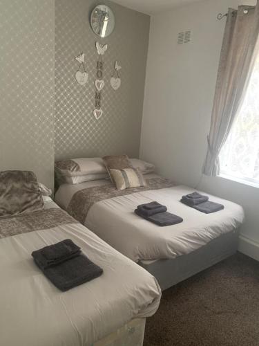 two beds in a bedroom with towels on them at The Butterfly Hotel in Blackpool