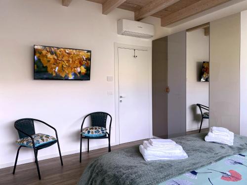 una habitación con 2 sillas y un cuadro en la pared en B&B La Villetta, en Bellante