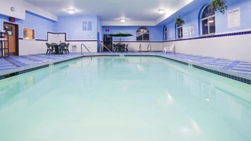 an indoor swimming pool with blue walls and blue tiles at Holiday Inn Express Deforest, an IHG Hotel in De Forest