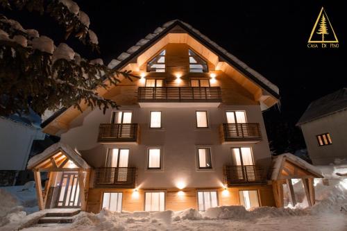 a large building in the snow at night at Casa di Pino EcoLodge Hotel in Žabljak