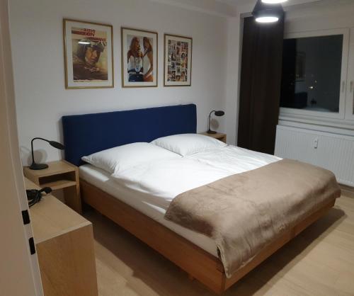 a bedroom with a large bed with a blue headboard at Appartment Zentrum Wels in Wels