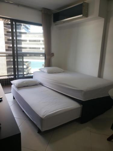 two beds in a room with a large window at Landscape Diamond 1409 in Fortaleza