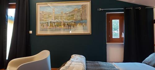 a bedroom with a painting on the wall and a chair at Casa Lady in Garda