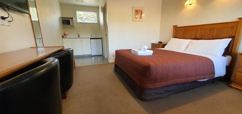 a hotel room with a bed and a kitchen at Rosewood Court Motel in Christchurch