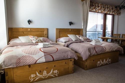 two beds sitting next to each other in a bedroom at Studio Livia in Vysoke Tatry - Stary Smokovec