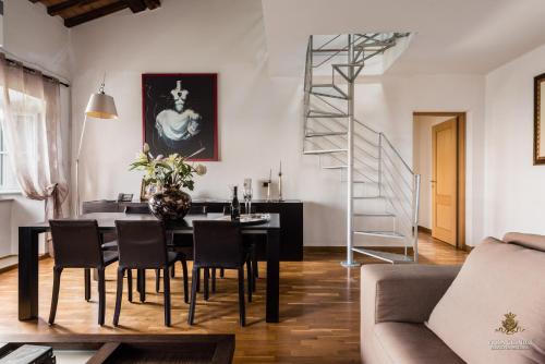 a dining room with a table and chairs and a staircase at Villa Guinigi Dimora di Epoca Exclusive Residence & Pool in Lucca