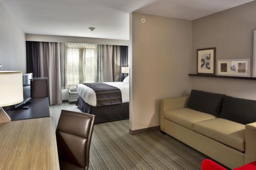 a hotel room with a bed and a couch at Country Inn & Suites by Radisson, Springfield Southeast in Springfield