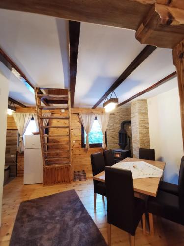 a dining room with a wooden table and chairs at Vila Tijana in Mitrovac