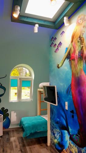 a room with a mermaid mural on the wall at Chata w Rabce - Bajkowa Osada in Rabka