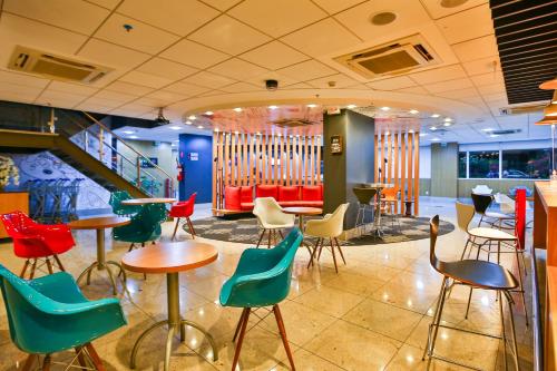 a restaurant with colorful chairs and tables and stairs at ibis Rio de Janeiro Botafogo in Rio de Janeiro