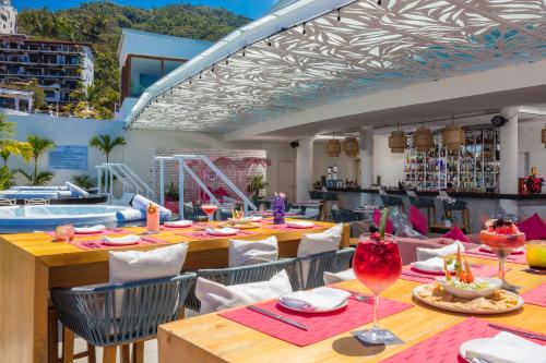 a dining room with tables and chairs and a pool at Almar Resort Luxury LGBT Beach Front Experience in Puerto Vallarta