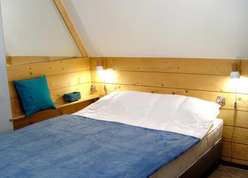 a bedroom with a large bed with a blue pillow at Apartamenty Jagiellonka in Zakopane
