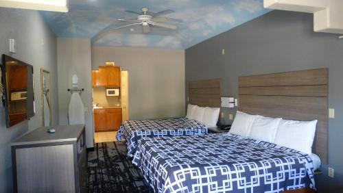 Habitación de hotel con 2 camas y ventilador de techo. en Regency Inn and Suites Humble, en Humble