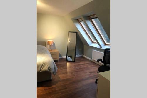 1 dormitorio con cama y espejo en Private Coach house in gated residence, en Stirling